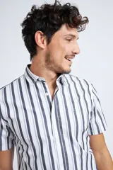 Camisa de corte slim fit con estampado de cuadros en tonos rojos, azules, blancos y negros. Presenta cuello clásico, cierre frontal abotonado y logo bordado en el pecho.