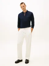 Chomba de manga larga Tommy Hilfiger de color azul marino, confeccionada en algodón con acabado Liquid Touch. Presenta cuello clásico, cierre frontal con cremallera corta y detalles tricolores en el interior de la abertura. Cuenta con puños acanalados y el logo bordado de la marca en el pecho.