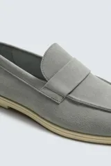 Mocasín casual de hombre, color marrón oscuro (bordó), fabricado en piel con acabado serraje (gamuza). Presenta un detalle de antifaz en el empeine y suela a contraste de color beige claro.