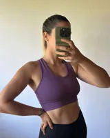 Top deportivo sin relleno, color lila jaspeado, con breteles anchos y escote redondo.