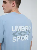 Remera Umbro de manga corta, color celeste, con cuello redondo y el logo de la marca bordado en el pecho.