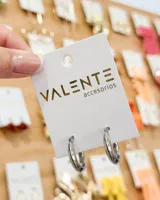 Aros tipo argolla de acero inoxidable, con diseño liso y acabado brillante. Cuentan con un sistema de cierre a presión integrado.