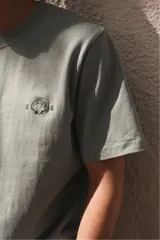 Remera de algodón color verde claro con cuello redondo y un pequeño bordado en el pecho.