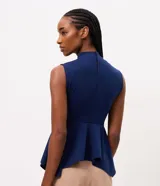 Blusa azul marino sin mangas de la marca Cortelle, con cuello alto, recortes estructurales y dobladillo estilo peplum asimétrico.