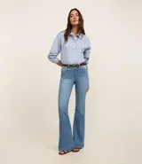 Pantalón flare de jeans con elastano, tiro alto, bolsillos delanteros y traseros, cierre con botón y cremallera, trabillas en la cintura.