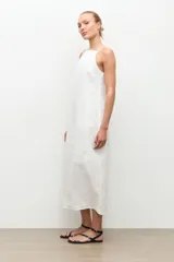 Vestido midi de lino color blanco, de corte recto y holgado, con escote cuadrado y tirantes finos.
