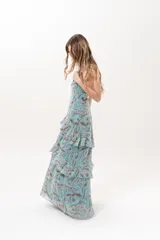 Vestido largo celeste con estampado abstracto en tonos marrones, escote halter con abertura en el frente y volados escalonados en la falda.