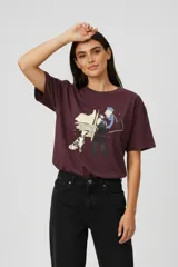 Remera de algodón color bordó, de corte holgado y manga corta, con cuello redondo y estampado artístico en el frente que representa a una mujer con un perro dálmata.