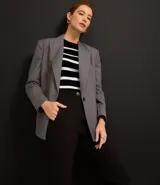 Pantalón zanahoria de sastrería color blanco, con cintura alta, trabillas y botón contrastante.