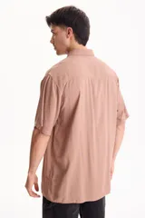 Camisa de viscosa negra de manga corta, con cuello camisero y cierre frontal de botones, de corte oversize.