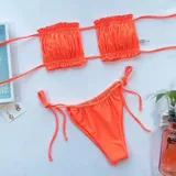 Bombacha de bikini tanga naranja con diseño plisado y tiras laterales ajustables. Fabricada en licra.