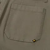 Pantalón de gabardina color verde oliva, de corte ancho y largo a la pantorrilla, con bolsillos delanteros tipo parche.