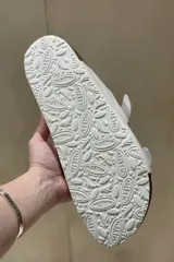 Sandalias de cuero color gris con glitter, con dos tiras anchas ajustables con hebillas metálicas plateadas. Suela anatómica de corcho y goma.