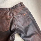 Pantalón de cuero vacuno negro, de tiro alto y corte recto con aberturas laterales en los bajos.