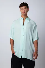 Camisa de manga corta con cuello cubano, confeccionada en fibrana premium. Presenta un corte oversize y cierre frontal con botones al tono.