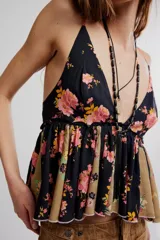 Top estilo babydoll de viscosa color rosado con estampado floreado, escote en V pronunciado, tirantes finos y detalles de volados combinados con paneles en tono crudo.