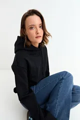 Canguro liso de color bordó, con capucha ajustable mediante cordones y bolsillo frontal tipo canguro.