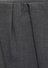 Falda midi de corte evasé en color gris, con diseño de pliegues en la cintura y cierre lateral oculto.