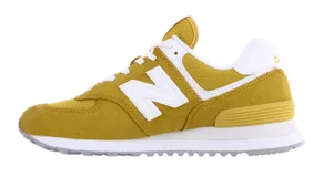 Championes urbanos New Balance modelo 574, color amarillo mostaza con detalles en blanco. Confeccionados en una combinación de gamuza y malla, presentan el logo N característico en los laterales y entresuela con tecnología ENCAP para mayor amortiguación.
