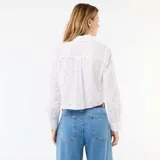 Camisa blanca de manga larga con diseño cropped, cuello camisero, cierre frontal con botones y detalles de bordados all over con perforaciones.