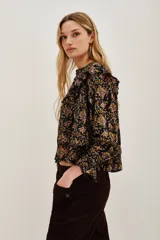 Camisa de manga larga con estampado paisley en tonos negros, amarillos y rosados. Presenta volados en los hombros, puños con terminación en volado y cierre frontal con botones.