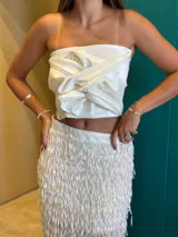 Top strapless de satén color bronce, con diseño de nudo frontal y drapeado estructurado.