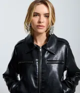 Campera de cuero sintético (PU) color negro, con cuello inglés, cierre frontal por cremallera y bolsillos laterales con cierre en el pecho. Presenta un diseño regular con mangas largas.