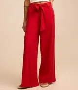 Pantalón de corte pantalona ancho, color rojo vibrante, confeccionado en viscosa y lino. Presenta un lazo de tela para atar en la cintura.