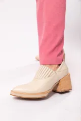 Zapato de cuero color beige con punta fina y taco de madera.