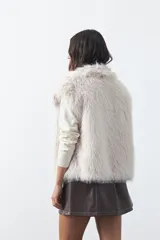 Chaleco de piel sintética con textura suave y volumétrica, de silueta recta y diseño sin mangas.