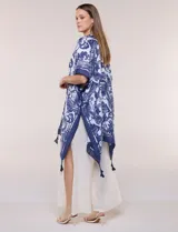 Kimono de gasa ligera con estampado floral en tonos de azul y blanco, silueta amplia, mangas cortas y detalle de borlas en el ruedo asimétrico.