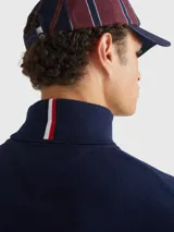 Suéter de cuello tortuga color azul marino, de corte regular, confeccionado en una mezcla de algodón Pima y cachemira. Presenta cuello, puños y bajo de punto canalé y un pequeño logo bordado en el pecho.