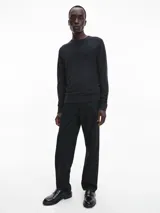 Sweater gris oscuro de lana merino 100% certificada, con cuello redondo y logo de Calvin Klein bordado en el pecho.