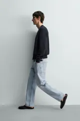 Pantalón de jean color celeste con efecto lavado, de corte recto y tiro medio, con diseño de cinco bolsillos y cierre frontal con botones.