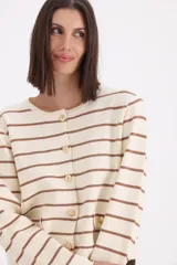 Cardigan de punto a rayas horizontales en color crema y marrón, con cuello redondo, cierre frontal de botones y dos bolsillos pequeños decorativos en la parte inferior.