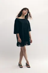 Remerón gris de cuello bote, con bordado del monograma de la marca a tono y encaje blanco integrado en el ruedo. Confeccionado en malla fina compactada de algodón.