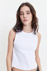 Musculosa blanca de tejido acanalado (rib) con escote recto y apliques metálicos pequeños distribuidos por toda la prenda.