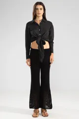 Camisa negra de manga larga con lazo en la cintura y botones nacarados.