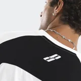 Remera de algodón con corte oversize, diseño bicolor en negro y blanco con paneles laterales en contraste. Presenta logo bordado en el frente y en la espalda.