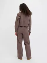 Sobrecamisa marrón con rayas verticales blancas, de corte corto, con cuello clásico, cierre frontal con botones y un bolsillo aplicado en el pecho.