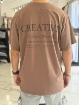 Remera oversize marrón con estampado tipográfico en la espalda y mangas cortas.
