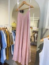 Vestido largo confeccionado en 100% lino de color naranja tierra, con escote en V y tirantes finos. Presenta un diseño fluido y minimalista ideal para la temporada de verano.