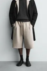 Bermuda de corte oversize confeccionada en tejido técnico compacto con elasticidad. Presenta cintura elástica ajustable con cordón, pinzas en el delantero y la espalda, y bolsillos laterales.