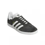 Championes adidas Gazelle de diseño clásico, confeccionados en gamuza color gris oscuro con las icónicas tres tiras laterales en blanco. Presentan suela de goma blanca, lengüeta blanca con logo y detalle de marca en dorado en el lateral.