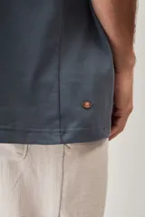 Remera oversize azul con mangas anchas, cuello redondo con textura tejida y estampa frontal pequeña a la altura del pecho.