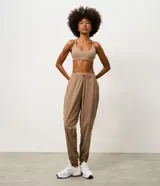 Pantalón jogger deportivo de microfibra, color tostado, con cintura elástica ajustable y puños elásticos en los tobillos. Diseño funcional y liviano, ideal para actividades físicas.