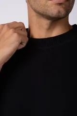 Remera de punto color crema, de manga corta, con cuello redondo acanalado y corte oversize.