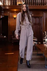 Pantalón color visón de corte ancho, con pinzas y bolsillos laterales.