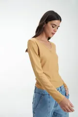 Remera azul de punto canalé, de manga larga y escote en V con botones.