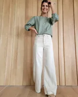 Pantalón de jean ancho con costuras verticales decorativas al frente y ruedo desflecado.